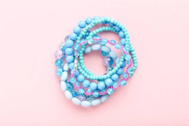 Pembe arka planda güzel mavi bilezikler