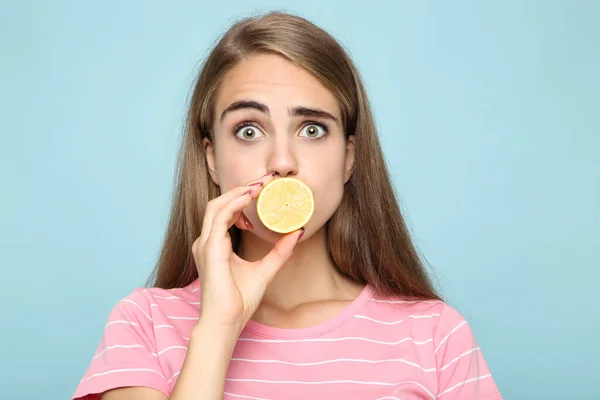 Mladá Dívka Drží Kus Citronu Modrém Pozadí — Stock fotografie