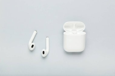 Gri arkaplanda beyaz kablosuz kulaklıklar