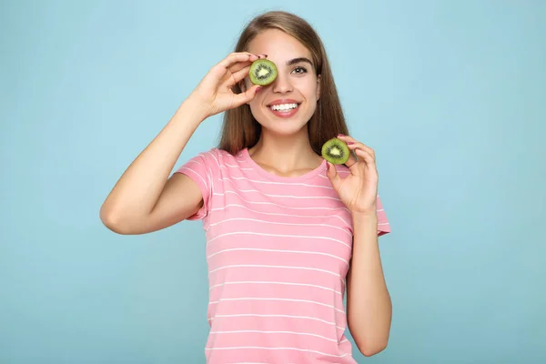 Młoda Dziewczyna Gospodarstwa Owoców Kiwi Niebieskim Tle — Zdjęcie stockowe