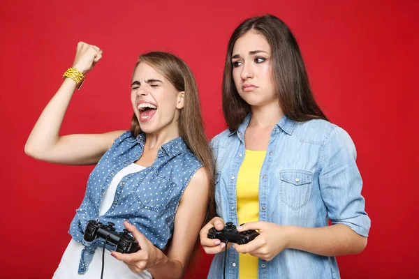 Jong Gelukkig Vriendinnen Spelen Computer Spel Met Joysticks Rode Achtergrond — Stockfoto