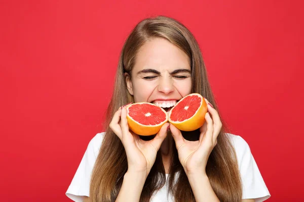 Mladá Dívka Jíst Čerstvé Grapefruit Červeném Pozadí — Stock fotografie