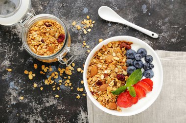 Gri arka planda taze böğürtlenli lezzetli granola