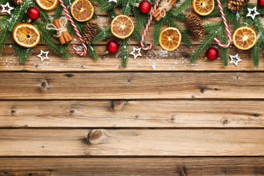 Kahverengi ahşap masa üzerinde Noel süsleri olan fidan dalları