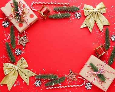 Kırmızı arka planda hediye kutuları olan Noel süsleri