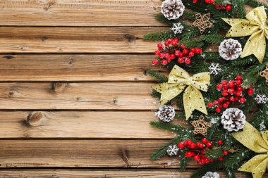 Kahverengi ahşap masa üzerinde Noel süsleri olan fidan dalları