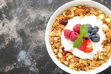 Gri arka planda taze böğürtlenli lezzetli granola