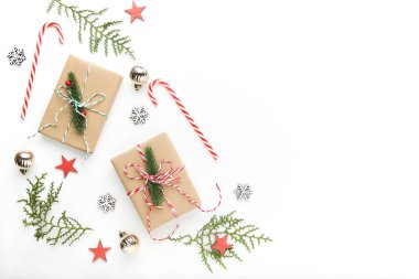 Beyaz arka planda hediye kutuları olan Noel süsleri