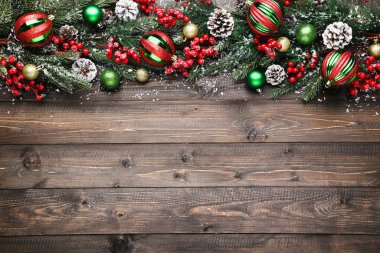 Kahverengi ahşap masa üzerinde Noel süsleri olan fidan dalları