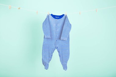 Mavi arka planda asılı bebek kıyafetleri