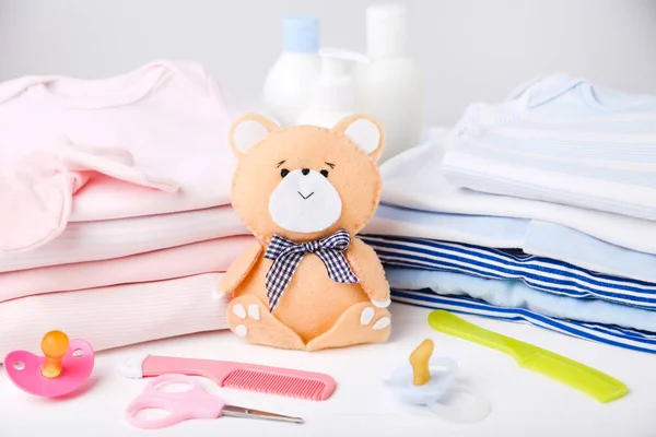 Ditutup Pakaian Dengan Mainan Beruang Lembut Dan Perlengkapan Bayi — Stok Foto