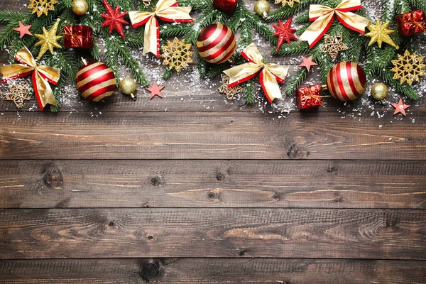 Kahverengi ahşap masa üzerinde Noel süsleri olan fidan dalları