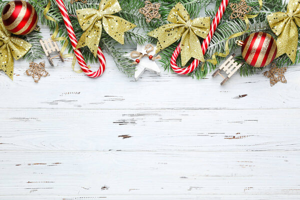 Fir tree branches with christmas ornaments on white wooden table