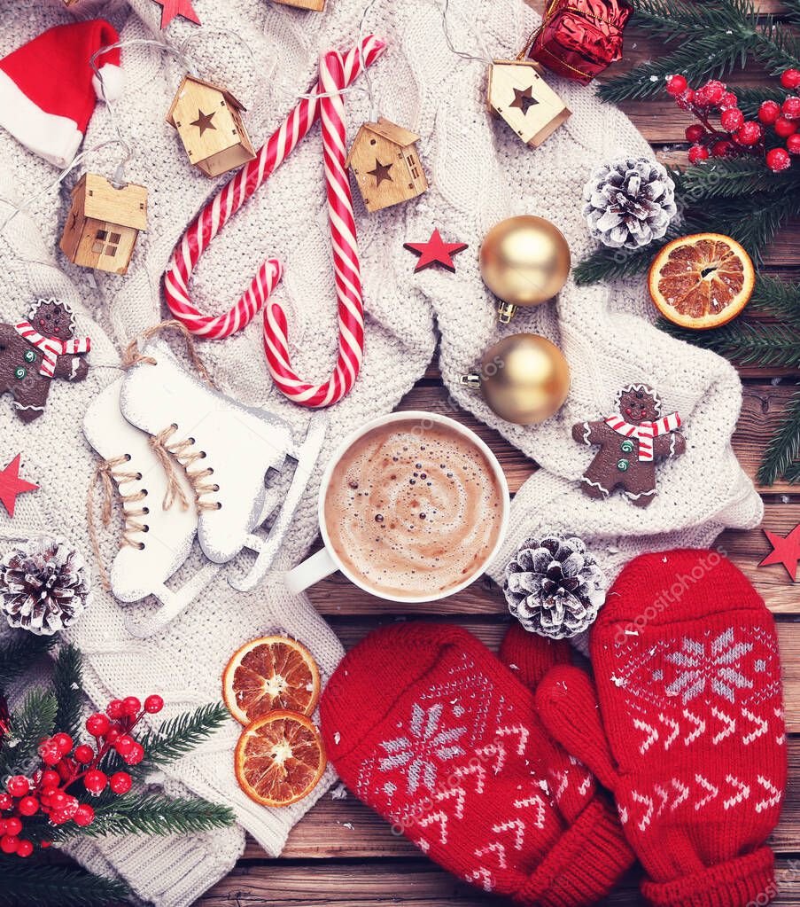 Cup of coffee with christmas ornaments, cookies, dry oranges and fir tree branches on wooden background