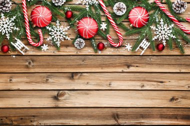 Kahverengi ahşap masa üzerinde Noel süsleri olan fidan dalları