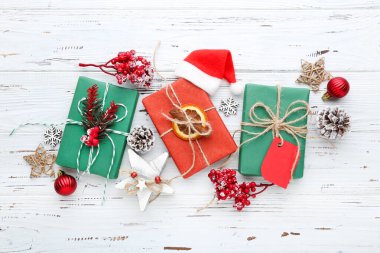 Beyaz ahşap arka planda süsleri olan hediye kutuları