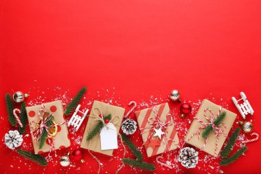 Kırmızı arkaplanda süslemeleri olan hediye kutuları