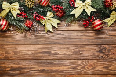 Kahverengi ahşap masa üzerinde Noel süsleri olan fidan dalları