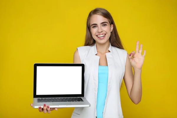 Piękna Kobieta Trzyma Laptopa Pokazuje Gest Żółtym Tle — Zdjęcie stockowe