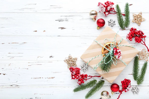 Beyaz ahşap arka planda süslemeleri olan hediye kutusu