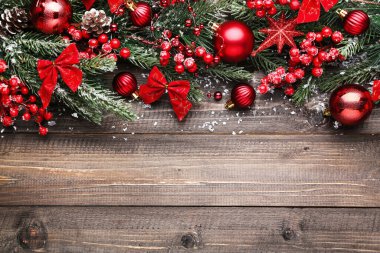 Kahverengi ahşap masa üzerinde Noel süsleri olan fidan dalları