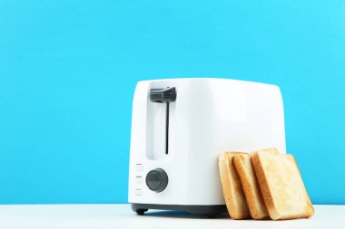 Mavi arka planda kızarmış ekmek kızartma makinesi.