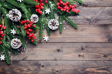Kahverengi ahşap masa üzerinde Noel süsleri olan fidan dalları
