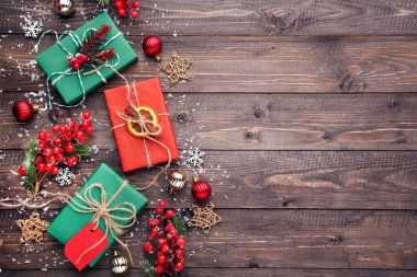 Kahverengi ahşap arka planda süslemeleri olan hediye kutusu.