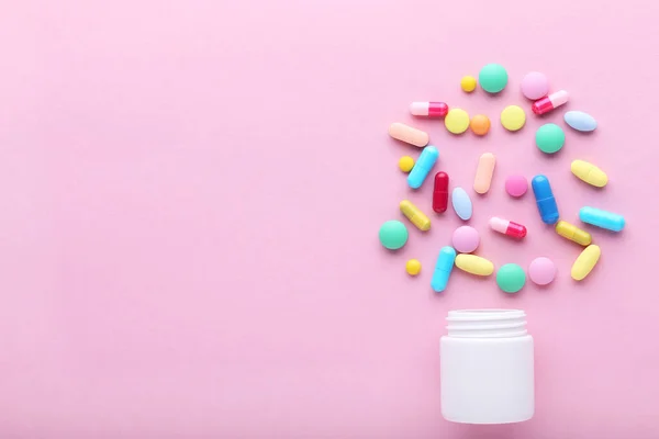 粉色背景的五颜六色药丸和药瓶 — 图库照片