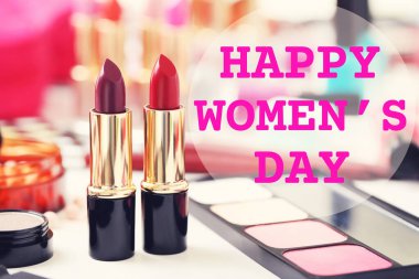 Colourful lipsticks with text Happy Womens Day on a white table