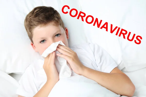 白いベッドとテキストコロナウイルスに横たわっているハンカチと病気の男の子 — ストック写真