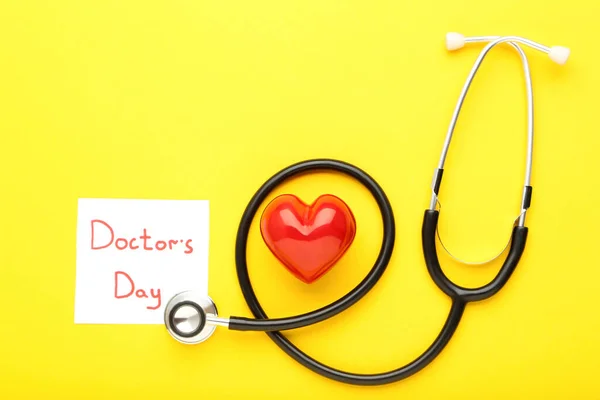 Stethoscope Κόκκινη Καρδιά Και Κείμενο Ημέρα Του Γιατρού Κίτρινο Φόντο — Φωτογραφία Αρχείου