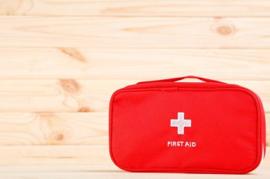 Kahverengi ahşap arka planda ilk yardım çantası