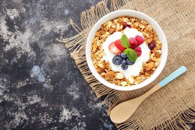 Gri arka planda taze böğürtlenli lezzetli granola