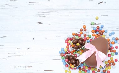 Beyaz ahşap masa üzerinde paskalya çikolatası ve şeker.