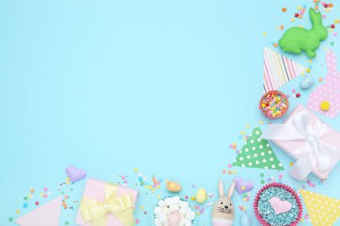 Paskalya konsepti. Kağıt bayraklar beyaz hediye kutuları, yumurtalar ve mavi arka planda serpiştirmeler