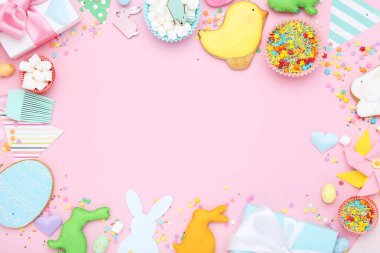 Paskalya zencefilli kurabiyeler hediye kutuları, kumaş tavşanlar ve pembe arka planda serpiştirmeler.