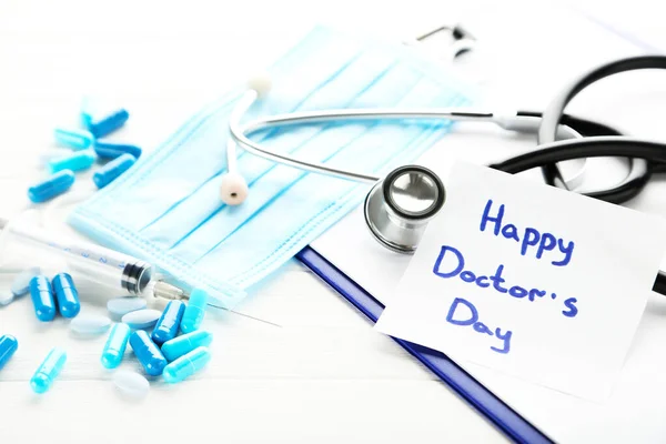 Testo Happy Doctor Day Con Stetoscopio Pillole Blu Siringa Tavolo — Foto Stock