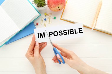 Kelime kesmek için makas kullanan kadın elleri Not defterleri ve elmalarla imkansızdır.