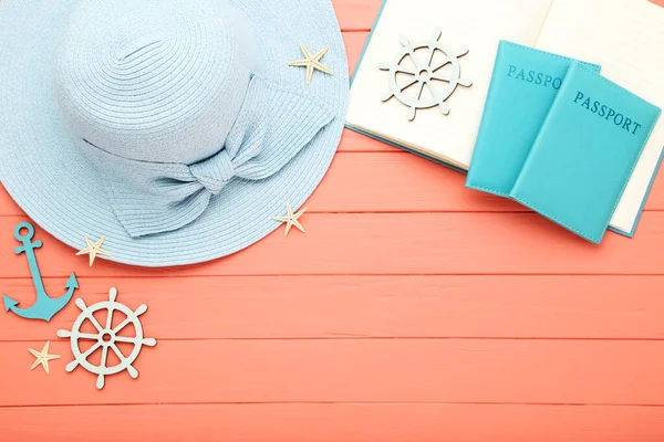Summer straw hat with notepad, passports and starfishes on wooden table