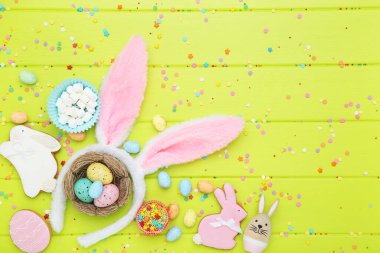Paskalya konsepti. Yumurtalı zencefilli kurabiye, marşmelov ve yeşil ahşap masada tavşan kulağı.