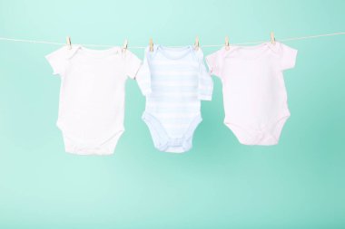 Mavi arka planda asılı bebek kıyafetleri