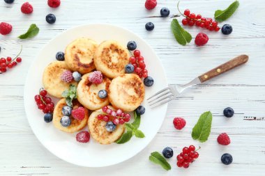 Böğürtlenli krep ve ahşap masada nane yaprağı.