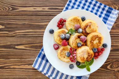 Böğürtlenli krep ve ahşap masada nane yaprağı.