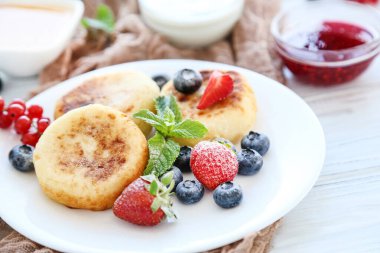 Böğürtlenli krep ve ahşap masada nane yaprağı.
