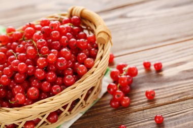 Ahşap arka planda sepetin içinde tatlı kırmızı üzümler.