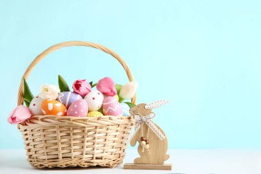 Lale çiçekli Paskalya yumurtaları ve mavi arka planda ahşap bir tavşan.