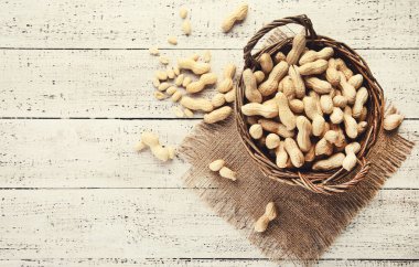 Beyaz ahşap masada sepetteki fıstıklar.