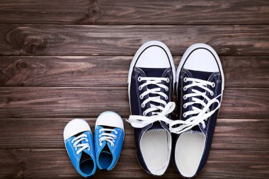 Babalar Günü konsepti. Kahverengi ahşap masada babanın ve oğlunun ayakkabıları.