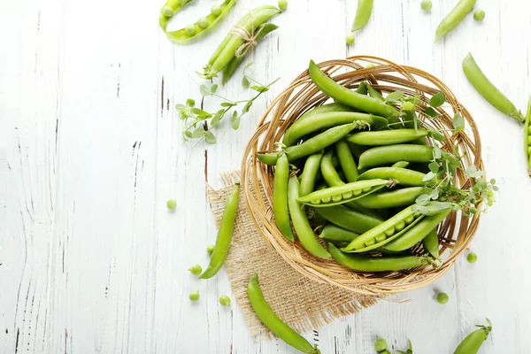 Grüne Erbsenschoten Korb Auf Weißem Holztisch — Stockfoto